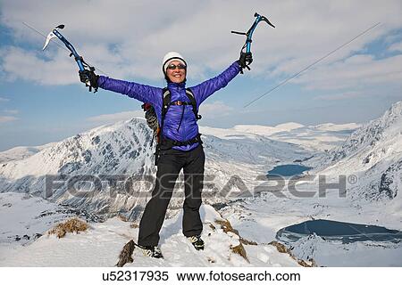 Female climber celebrating on top of snow covered peak View Large Photo Image Stock Photography - Female climber celebrating on top of snow covered peak. Fotosearch