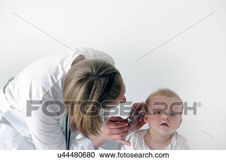 Female doctor examining baby's ear View Large Photo Image Stock Image - Female doctor examining baby's ear. Fotosearch
