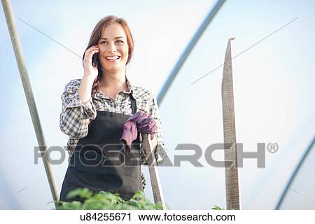 Female farm worker on cellphone View Large Photo Image Stock Image - Female farm worker on cellphone. Fotosearch
