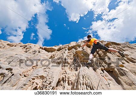 Female rock climber nearing cliff top View Large Photo Image Stock Image - Female rock climber nearing cliff top. Fotosearch