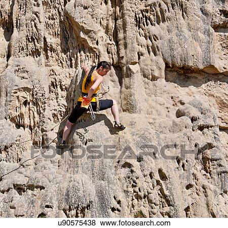 Stock Photo - Female rock climber on rock face. Fotosearch
