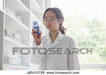 Female scientist holding bottle View Large Photo Image Stock Photo - Female scientist holding bottle. Fotosearch