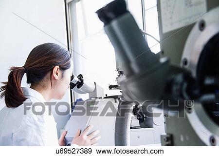 Female scientist looking through microscope View Large Photo Image Stock Photo - Female scientist looking through microscope. Fotosearch