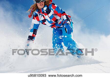Stock Image - Female snowboarder in action. Fotosearch