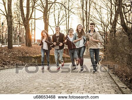 Five teenagers running through park View Large Photo Image Stock Photo - Five teenagers running through park. Fotosearch
