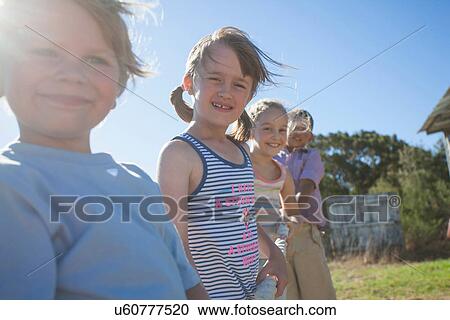 Stock Image - Four children outside in summer. Fotosearch