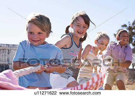 Four children playing tug of war View Large Photo Image Stock Image - Four children playing tug of war. Fotosearch