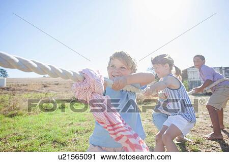 Four children playing tug of war View Large Photo Image Stock Image - Four children playing tug of war. Fotosearch