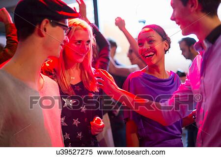 Stock Photography - Four young adults laughing at party. Fotosearch