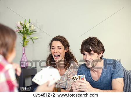 Stock Image - Friends playing cards. Fotosearch