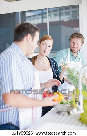 Stock Photograph - Friends preparing food together. Fotosearch