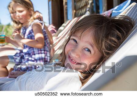Stock Image - Girl relaxing in shade in summer. Fotosearch