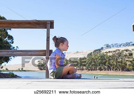 Girl sitting on pier, side view View Large Photo Image Stock Image - Girl sitting on pier, side view. Fotosearch