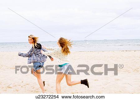 Girlfriends playing chasing game on the beach View Large Photo Image Picture - Girlfriends playing chasing game on the beach. Fotosearch