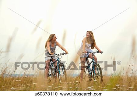 Girls riding bikes View Large Photo Image Stock Image - Girls riding bikes. Fotosearch