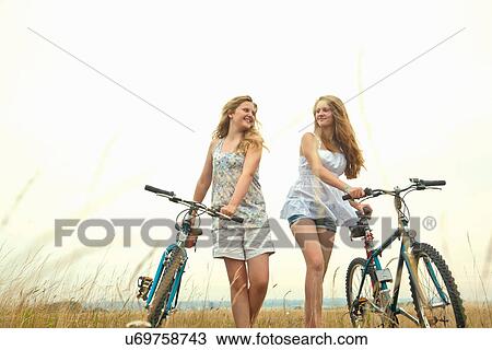Stock Image - Girls with bikes. Fotosearch