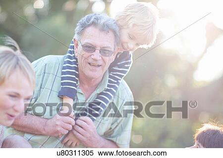 Grandfather giving grandson piggy back View Large Photo Image Stock Photography - Grandfather giving grandson piggy back. Fotosearch