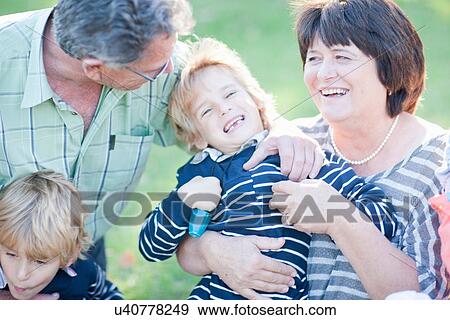 Stock Photo - Grandparents tickling grandson. Fotosearch