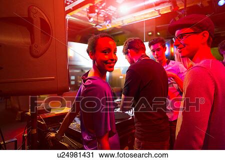 Stock Image - Group of people behind mixing desk. Fotosearch