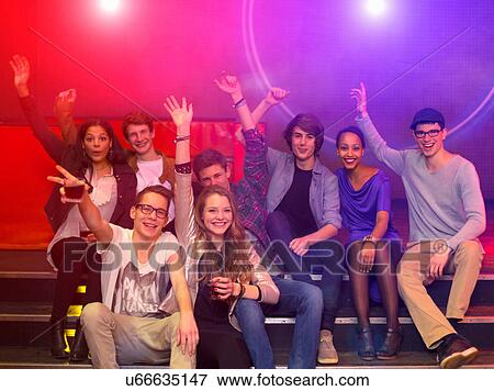 Group of teenagers and young adults at party holding drinks and raising arms View Large Photo Image Stock Photo - Group of teenagers and young adults at party holding drinks and raising arms. Fotosearch
