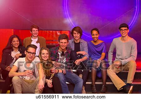 Group of teenagers and young adults sitting on step at party holding drinks View Large Photo Image Stock Image - Group of teenagers and young adults sitting on step at party holding drinks. Fotosearch