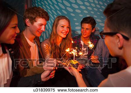 Group of teenagers sitting around birthday cake with sparklers View Large Photo Image Stock Photography - Group of teenagers sitting around birthday cake with sparklers. Fotosearch