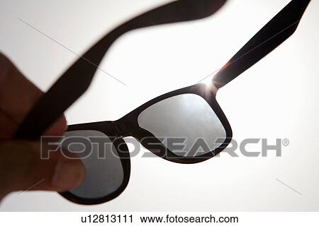 Hand holding sun glasses View Large Photo Image Stock Image - Hand holding sun glasses. Fotosearch