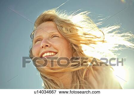 Stock Photo - Happy girl with sunlight in her hair. Fotosearch
