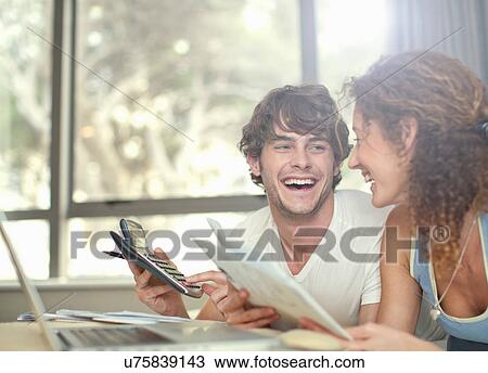 Stock Image - Happy young couple planning finances. Fotosearch