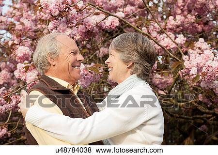 Stock Photo - Husband and wife embracing in garden. Fotosearch