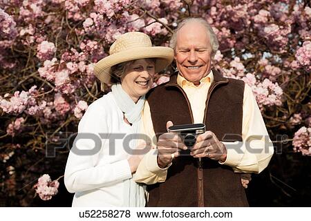 Husband and wife smiling and looking at camera in hand View Large Photo Image Stock Photo - Husband and wife smiling and looking at camera in hand. Fotosearch
