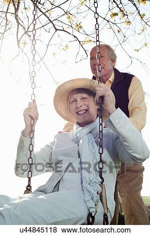 Husband pushing wife on swing View Large Photo Image Stock Photo - Husband pushing wife on swing. Fotosearch