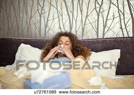 Ill young woman in bed with tissues View Large Photo Image Stock Photo - Ill young woman in bed with tissues. Fotosearch