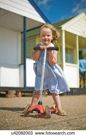 Little girl on scooter near beach huts View Large Photo Image Stock Image - Little girl on scooter near beach huts. Fotosearch