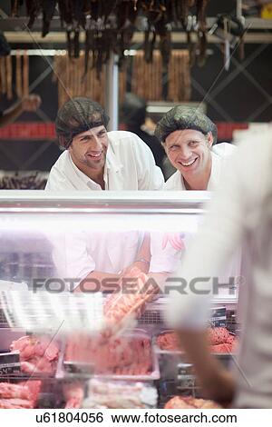 Male butchers working on counter View Large Photo Image Stock Photograph - Male butchers working on counter. Fotosearch