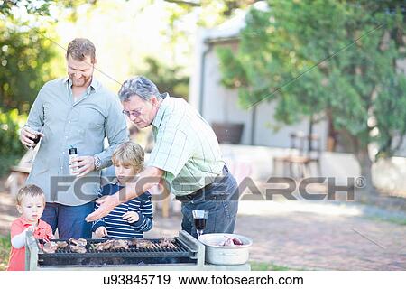Male family members barbecuing View Large Photo Image Stock Photo - Male family members barbecuing. Fotosearch