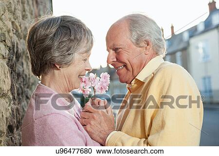 Man giving flower to wife View Large Photo Image Stock Image - Man giving flower to wife. Fotosearch