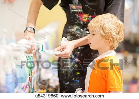Man helping boy get paint to use View Large Photo Image Stock Image - Man helping boy get paint to use. Fotosearch