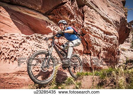 Man mountain biking next to rocks View Large Photo Image Stock Photography - Man mountain biking next to rocks. Fotosearch