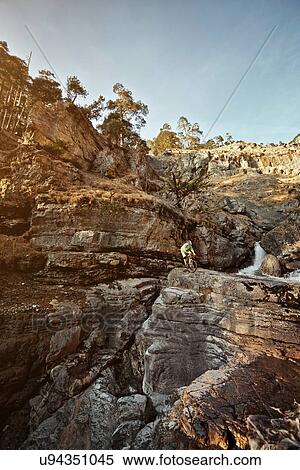 Man mountain biking on rocks by cliffs View Large Photo Image Stock Photography - Man mountain biking on rocks by cliffs. Fotosearch