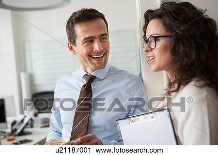 Mature man smiling at woman holding clipboard View Large Photo Image Stock Image - Mature man smiling at woman holding clipboard. Fotosearch