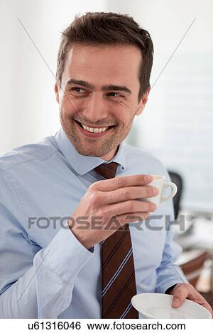Stock Photograph - Mature man wearing shirt and tie holding cup of coffee. Fotosearch