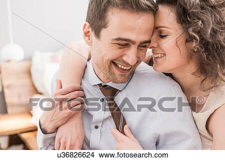Picture - Mid adult couple face to face with arm around, smiling. Fotosearch
