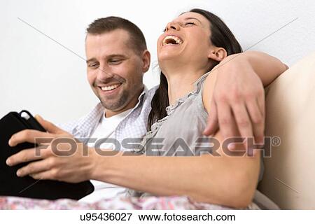 Mid adult couple looking at digital tablet together View Large Photo Image Stock Photo - Mid adult couple looking at digital tablet together. Fotosearch
