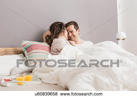 Mid adult couple lying in bed, breakfast on tray View Large Photo Image Stock Photo - Mid adult couple lying in bed, breakfast on tray. Fotosearch