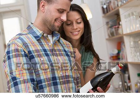 Mid adult couple selecting bottle of wine View Large Photo Image Stock Photograph - Mid adult couple selecting bottle of wine. Fotosearch