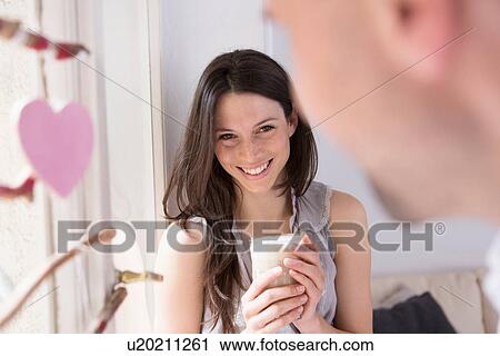 Stock Image - Mid adult couple sitting in window seat. Fotosearch