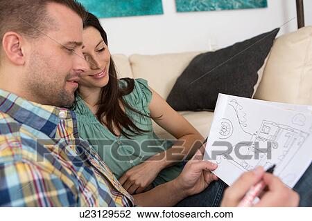 Mid adult couple sketching house plans View Large Photo Image Stock Image - Mid adult couple sketching house plans. Fotosearch