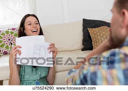 Stock Image - Mid adult couple sketching house plans. Fotosearch