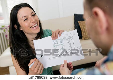 Stock Photo - Mid adult couple sketching house plans. Fotosearch